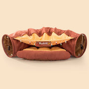 Collapsible cat tunnel with soft cushioned bed, interactive hanging toys, and washable durable fabric for playful pets.